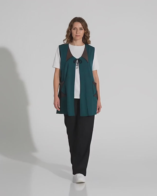 Βίντεο παρουσίασης σε περιβάλλον στούντιο όπου μια γυναίκα μοντέλο περπατάει αργά προς την κάμερα φορώντας το Μακρύ Εβαζέ Γιλέκο Λαδί με Δερματίνη και Κορδόνια Plus Size