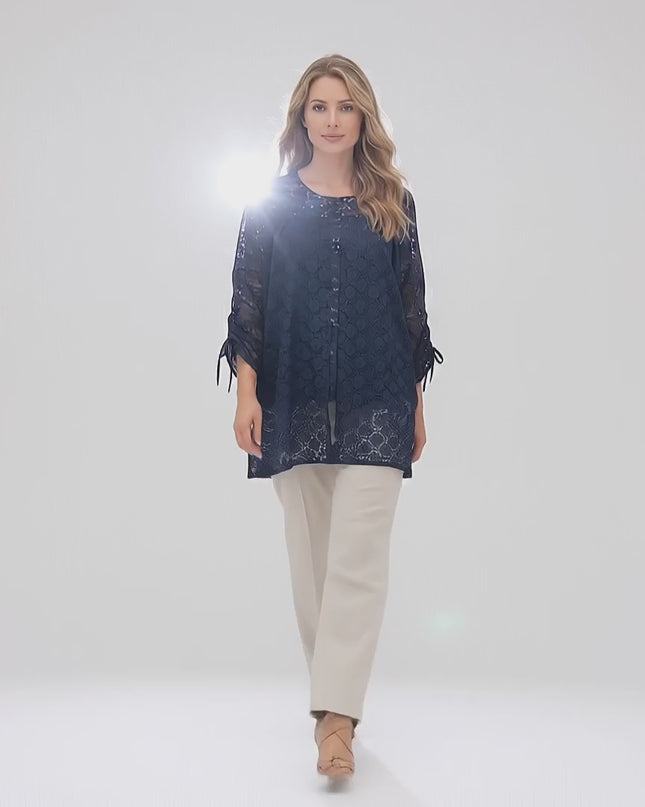 Βίντεο παρουσίασης όπου ένα plus-size μοντέλο περπατάει αργά προς την κάμερα σε περιβάλλον στούντιο με ουδέτερο φόντο φορώντας το προϊόν Επίσημη γυναικεία τουνίκ με φλοράλ δαντέλα σε σκούρο μπλε