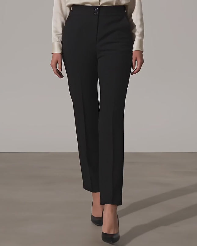 Ένα plus size μοντέλο περπατάει αργά προς την κάμερα σε περιβάλλον στούντιο με ουδέτερο φόντο, φορώντας το Μαύρο επίσημο γυναικείο παντελόνι μεγάλα μεγέθη με ελαστική μέση και ίσια γραμμή