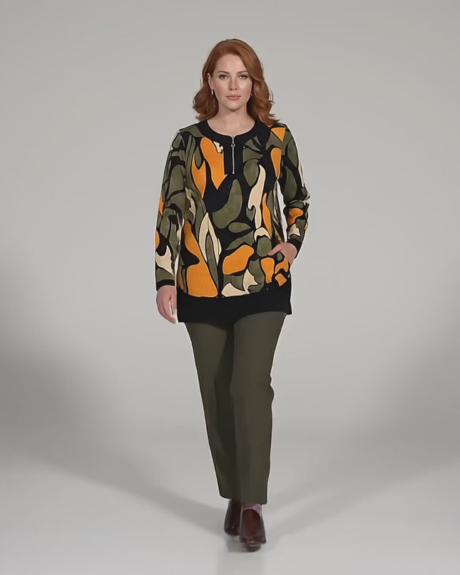 Σε περιβάλλον στούντιο, ένα plus-size μοντέλο περπατάει αργά προς την κάμερα ενώ φοράει το προϊόν Επίσημη εβαζέ τουνίκ μεγάλα μεγέθη με φερμουάρ και πολύχρωμο σχέδιο