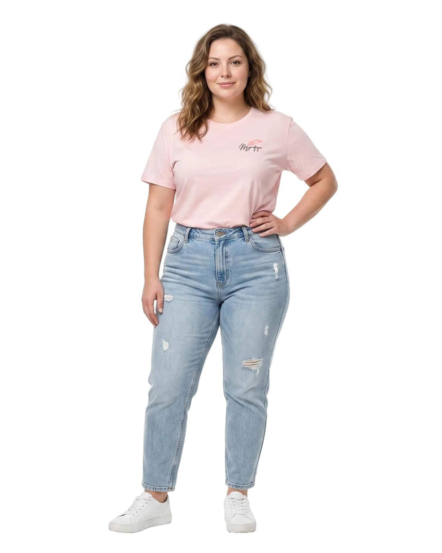 Ολόσωμη λήψη με ροζ βαμβακερό γυναικείο t-shirt με στάμπα σε μεγάλα μεγέθη, συνδυασμένο με τζιν παντελόνι και λευκά αθλητικά παπούτσια, σε λευκό φόντο.