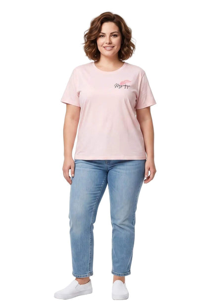 Ολόσωμη λήψη με ροζ βαμβακερό γυναικείο t-shirt με στάμπα σε μεγάλα μεγέθη, συνδυασμένο με τζιν παντελόνι και λευκά slip-on sneakers.