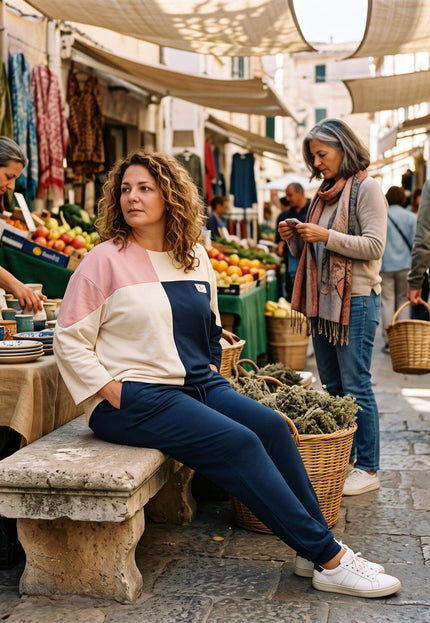 Ολόσωμη λήψη με plus size σετ μπλούζα και παντελόνα σε άνετη γραμμή, με color-block σχέδιο, φορεμένο σε εξωτερικό χώρο αγοράς.