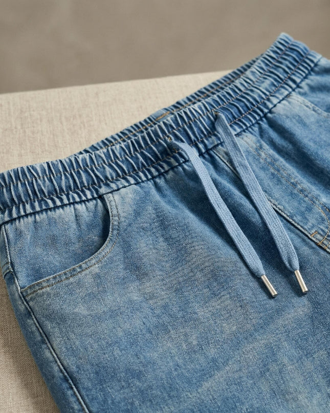 Детайл отблизо на сини макси дамски дънки, показващ еластичната талия с регулируеми връзки и горната част на страничните джобове.