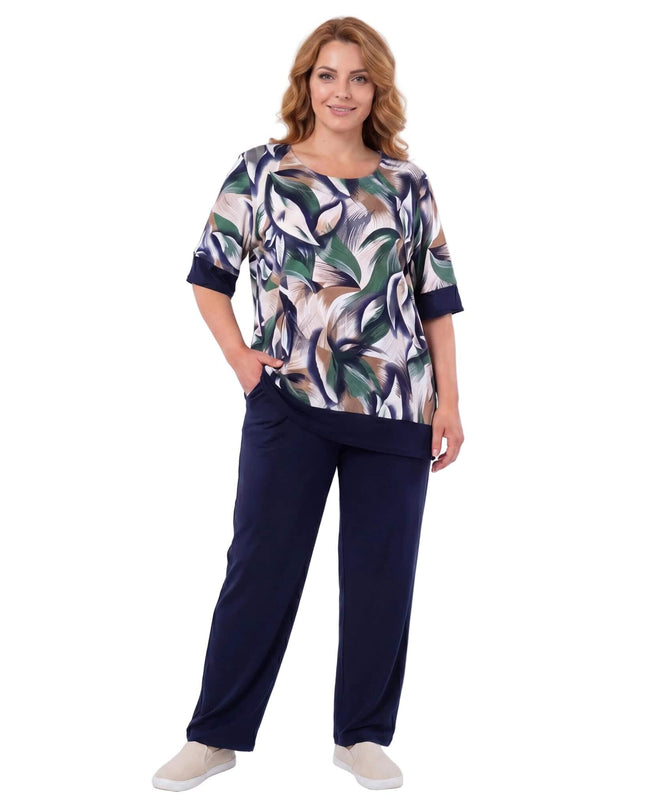 Γυναικείο plus size σετ με σκούρο μπλε παντελόνι και τουνίκ με print φύλλων. Ολόσωμη λήψη με το μοντέλο σε λευκό φόντο.