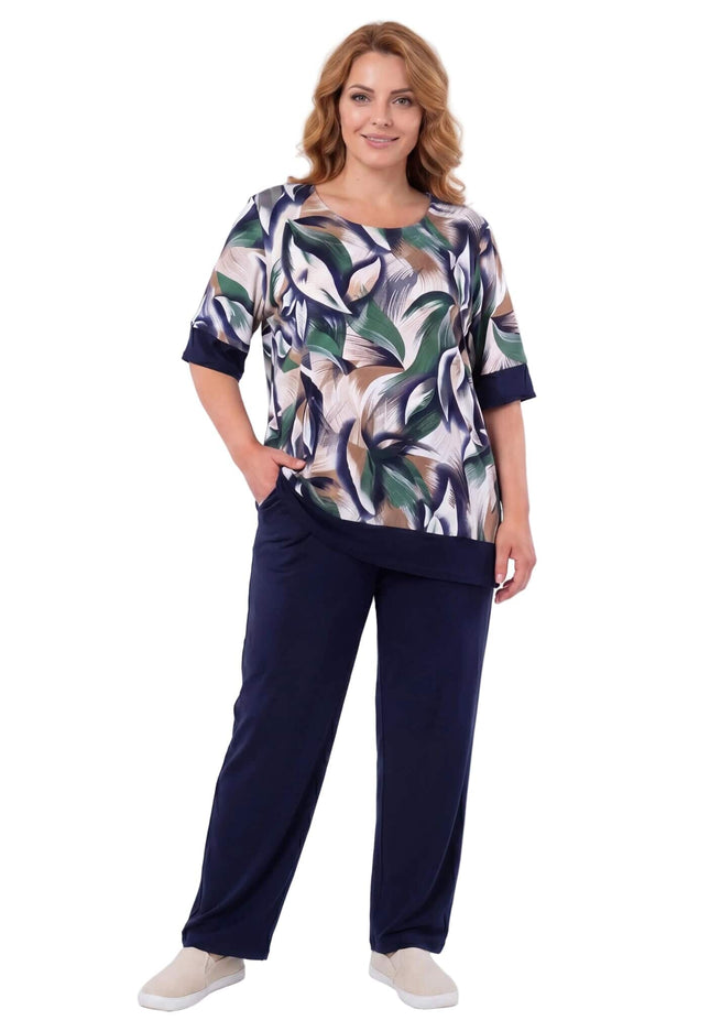 Γυναικείο plus size σετ με σκούρο μπλε παντελόνι και τουνίκ με print φύλλων. Ολόσωμη λήψη με το μοντέλο σε λευκό φόντο.