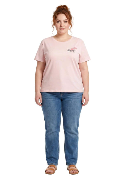 Ολόσωμη λήψη με plus size γυναικείο βαμβακερό t-shirt σε απαλό ροζ χρώμα με διακριτικό τύπωμα στο στήθος, συνδυασμένο με τζιν παντελόνι σε λευκό φόντο.